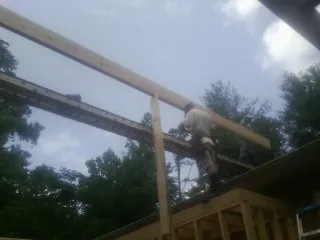 Carpenter setting a ridge beam over a new addition frame — Ice Dam Removal by Roofing Brothers in Tiplersville