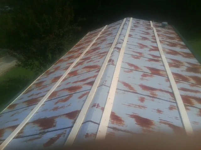 Rusted metal roof panels with new wood purlins before replacement — Storm Damage Roof Repair in Tiplersville by Roofing Brothers