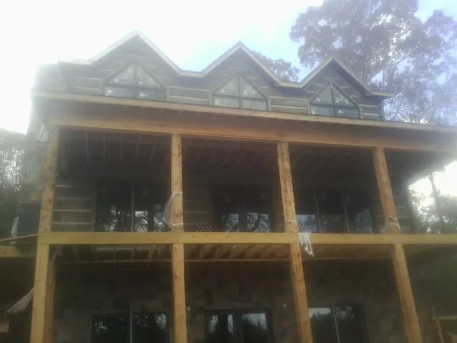 Dormers and porch framing on a large log home under construction — Roof Coating work by our crew in Tiplersville