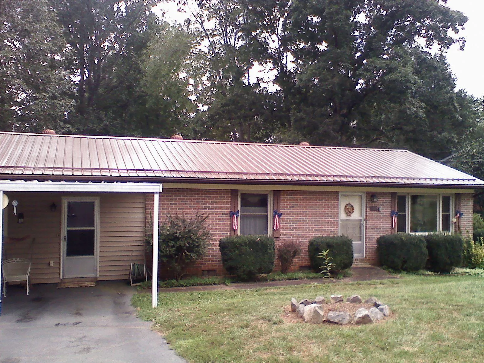 Bronze metal roof and carport on a brick ranch home — Roof Repair work by our crew in Tiplersville